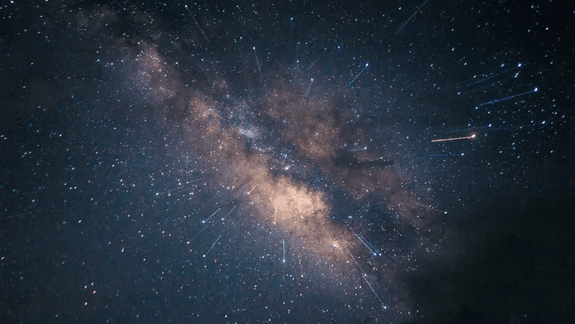 A star-filled night sky crossed by the Milky Way and meteor trails